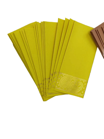 A fan of bright yellow paper envelopes with a decorative gold foil paisley border near the bottom, displayed on a textured white surface next to other colored envelopes.